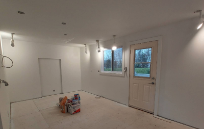 Pièce en rénovation avec murs blancs et bâches de protection